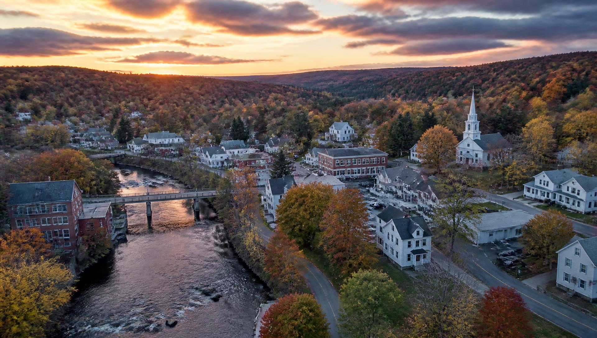 Aerial view of Springvale, Maine at sunset with the river and village center